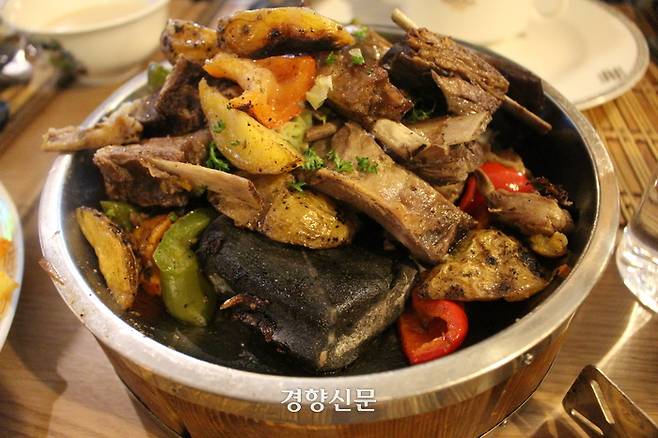 몽골의 전통음식 허르헉. 양고기와 야채 밑으로 까만색 돌이 보인다.