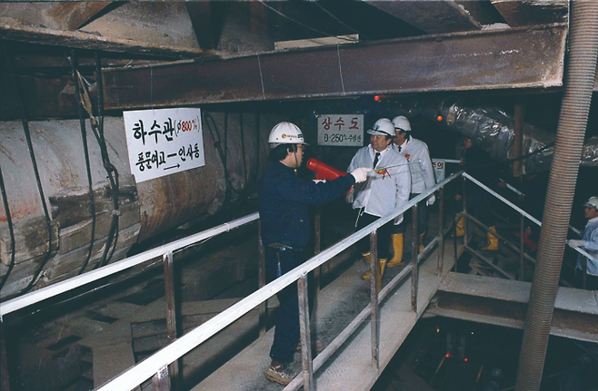 1984년 2월 서울 지하철 3호선 320공구(현 안국역) 터널 관통 현장의 모습. 지하철 3·4호선의 도심구간은 지하철 간 교차되는 곳이 많이 지하 깊숙이 건설해야 하는데다, 도로를 파헤치는 공법으로 건설할 경우 교통체증의 부작용이 커서 터널공법으로 건설되었다. [서울역사아카이브]