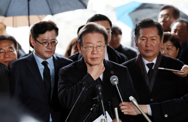 이재명 더불어민주당 대표가 5일 오전 광주 북구 국립 5·18 민주묘지를 참배한 뒤 목을 만지며 기자회견을 준비하고 있다. 이 대표는 이날 기자회견에서 비례대표 배분 방식을 준연동형으로 유지하겠다고 밝혔다. 연합뉴스