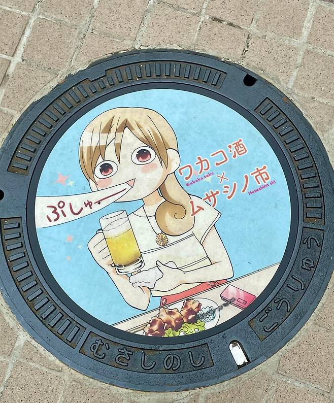 일본 도쿄 근처 소도시의 거리에 있는 맨홀 뚜껑. 만화 '와카코와 술'의 주인공 와카코는 음식과 술이 조화를 이룰 때 “푸슈~” 하고 행복한 감탄사를 내뱉는다.  /신큐 치에 SNS