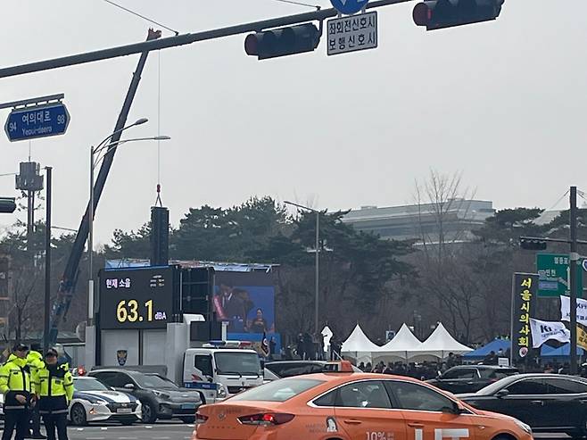 3일 서울 영등포구 여의대로에서 '의대정원 증원 및 필수의료 패키지 저지를 위한 전국 의사 총궐기 대회'가 열리고 있다. 김택우 의협 비대위원장이 연단에 올랐을 때 소음 측정 경찰 차량 스크린에는 63.1데시벨이 측정됐다. /김명지 기자