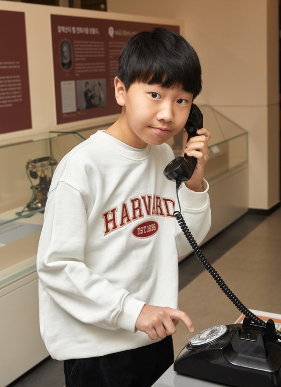 유정현 학생기자가 숫자마다 있는 구멍에 손가락을 넣고 돌려 전화를 거는 다이얼 전화기를 체험하고 있다.
