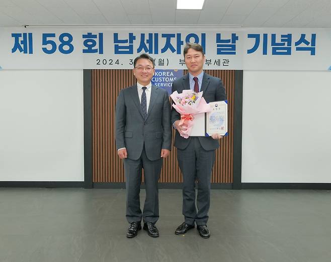 김동진 르노코리아 통관기획팀장(오른쪽)이 4일 부산본부세관에서 열린 '제58회 납세자의 날' 기념식에서 기획재정부장관 표창을 수상하고 장웅요 부산본부세관장과 기념촬영을 하고 있다(르노코리아 제공). ⓒ 뉴스1