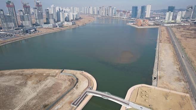 인천 송도국제도시 6공구 호수 전경. 워터프런트 1-2단계 사업은 이 호수와 아암호수를 연결하는 새로운 물길을 조성하는 사업이다.
 2027년 공사가 마무리되면서 호수와 수로를 조망할 수 있는 ‘친수 스탠드’를 비롯해 인조 볏집 퍼걸러, 대형막 구조 퍼걸러 등
 편의시설이 다양하게 설치된다. 인천경제자유구역청 제공