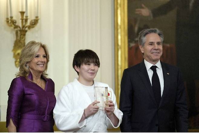 4일(현지 시간) 미국 워싱턴 D.C. 백악관에서 일본 자위대의 성폭력을 고발해 ‘세계의 용기 있는 여성상’을 수상한 고노이 리나(五ノ井里奈·가운데)가 질 바이든 여사(왼쪽), 토니 블링컨 국무장관과 함께 포즈를 취하고 있다. 워싱턴=AP 뉴시스