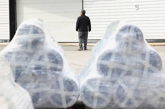 지난달 28일 오전 경기도 소재 한 공장에서 걸어가고 있는 관계자 뒤에 클린매트의 원료인 폴리에틸렌 원단이 놓여있다. 이 업체는 원료를 폴리에틸렌이 아닌 재활용 원료로 바꾸도록 요구받았다. 김영원 기자 forever@hani.co.kr