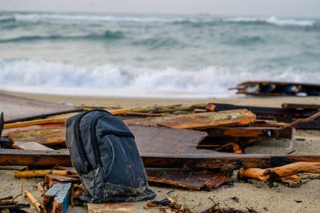 지난해 2월 이탈리아 남부 크로톤의 한 해안의 난파선 잔재 인근에 배를 타고 바다를 건너다 사망한 이주민의 것으로 추정되는 가방이 놓여 있다. 크로톤=AP 연합뉴스