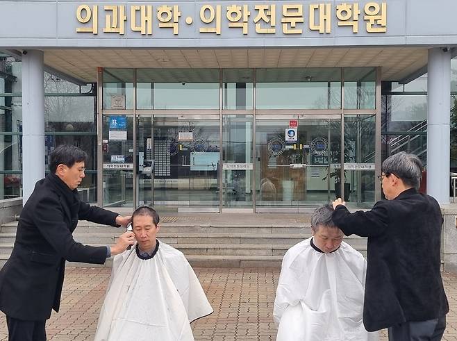 5일 오전 강원 춘천시 강원대학교 의과대학 앞에서 의대 교수들이 대학 측의 증원 방침에 반발하며 삭발하고 있다. [강원대학교 의대 교수진 제공] 사진=연합뉴스