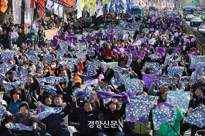 민주노총 가맹산하 조합원들과 여성 노동자들이 8일 서울 종로구 마로니에 공원에서 2024년 3.8 세계 여성의날 정신계승 전국노동자대회를 열고, 성별임금격차 해소, 여성노동권 쟁취 등을 촉구하며 보라색 손수건을 머리 위로 흔들고 있다.