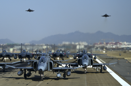 박정희 대통령 때인 1979년부터 도입돼 한반도 하늘을 주름잡은  F-4E 팬텀의 오는 6월 퇴역식을 앞두고 지난 8일 F-4E 8대를 필두로 모두 33대의 공군 전투기들이 ‘엘리펀트 워크(Elephant Walk)‘ 훈련을 진행하고 있는 가운데, F-35A 스텔스 전투기 2대가 대형 위를 저공비행(Low Pass) 하고 있다. 공군 제공