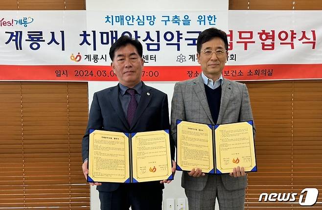 이금용 계룡보건소장(왼쪽)과 신하경 계룡약사회장이 치매관리사업 공동 추진을 위한 협약을 체결한 뒤 기념사진을 찍고 있다. (계룡시 제공) /뉴스1