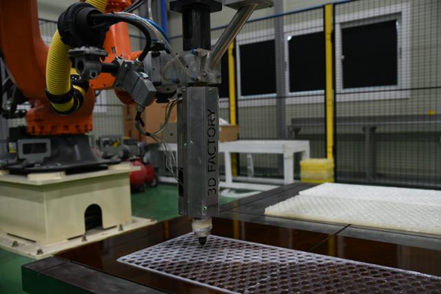 초대형 3D프린팅 전문기업 쓰리디팩토리가 개발한 다관절로봇 형태 3D프린터가 5일 부두에 쓰이는 방충재를 제작하고 있다. 울산=박은경 기자