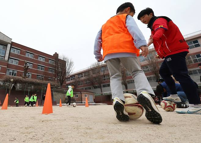서울 아현초등학교 '늘봄학교' 프로그램 중 축구에 참여한 학생들이 선생님과 다양한 기술을 체험하고 있다. [연합]