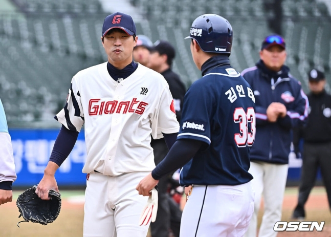 롯데 구승민(왼쪽)이 11일 사직 두산전에서 타구에 맞은 후 두산 김인태에게 미소를 지어보이고 있다.