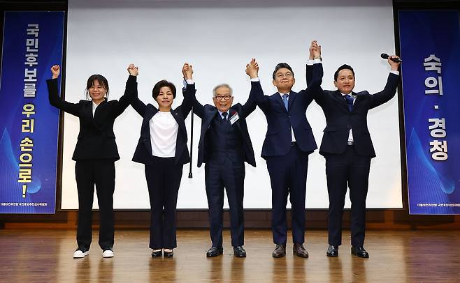 김상근 더불어민주연합 국민후보 추천 심사위원장이 10일 서울 중구 은행회관에서 열린 비례대표 국민후보 선출을 위한 공개 오디션에서 네 명의 최종 후보들과 손을 잡고 들어올리며 기념촬영을 하고 있다. 왼쪽부터 청년운동가 출신 전지예 씨, 농민 출신 정영이 씨, 김 위원장, 의료인 출신 김윤 씨, 임태훈 군인권센터 소장. /뉴시스