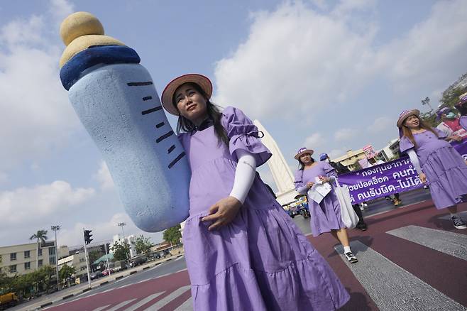 지난 8일(현지시각) 태국 방콕에서 세계 여성의 날 집회가 열려 임부복을 입은 여성 노동자들이 젖병 조형물 등을 들고 임신부에게 최대 180일 유급 출산 휴가를 줄 것을 요구하는 구호를 외치고 있다. /AP=뉴시스