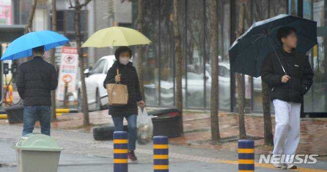 [전주=뉴시스] 김얼 기자 = 전북 전주시 덕진구 가련산로에서 시민들이 우산으로 비를 피하며 길을 지나고 있다. 2024.02.21. pmkeul@newsis.com