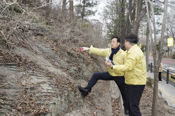 이승로(왼쪽) 성북구청장이 지난 11일 낙석 위험이 있는 곳에서 해빙기 맞이 안전점검을 진행하고 있다.   성북구 제공