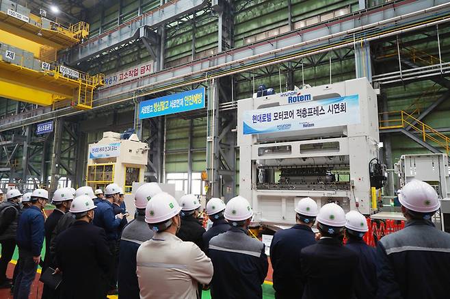 12일 충남 당진시 현대로템 당진 공장에서 개최된 '적층 프레스' 시연회에서 참석자들이 적층 프레스 설비(우)와 배터리캔 고속 프레스 라인(좌)를 둘러보고 있다