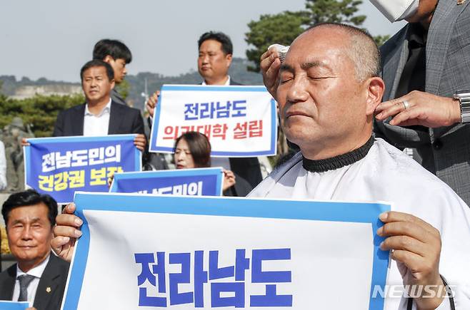 [서울=뉴시스] 정병혁 기자 = 더불어민주당 김원이 의원이 18일 서울 용산구 전쟁기념관 앞에서 열린 윤석열정권 전라남도 의과대학 유치 촉구 집회에서 삭발을 하고 있다. 2023.10.18. jhope@newsis.com