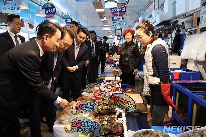 [사천=뉴시스] 조수정 기자 = 윤석열 대통령이 13일 경남 사천시 삼천포용궁수산시장을 찾아 어패류를 구매하고 있다. (대통령실통신사진기자단) 2024.03.13. chocrystal@newsis.com