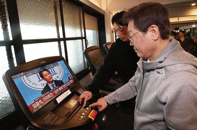 이재명 더불어민주당 대표가 2월 28일 서울 서대문구 매직짐 휘트니스에서 러닝머신을 이용하는 중, 화면에 임종석 전 대통령비서실장의 공천 관련 기자회견 모습이 보이고 있다. [사진공동취재단]