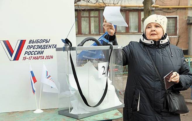 러시아가 점령한 우크라이나 동부 도네츠크주(州) 마케예프카에서 최근 한 러시아 국민이 접지 않은 투표용지를 투명한 대선 사전 투표함에 넣고 있다. /타스 연합뉴스
