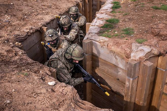 우크라이나 군 신병들이 14일(현지시각) 영국 동부 지역에서 덴마크 교관의 훈련을 받으며 참호를 통과하고 있다. /로이터 연합뉴스