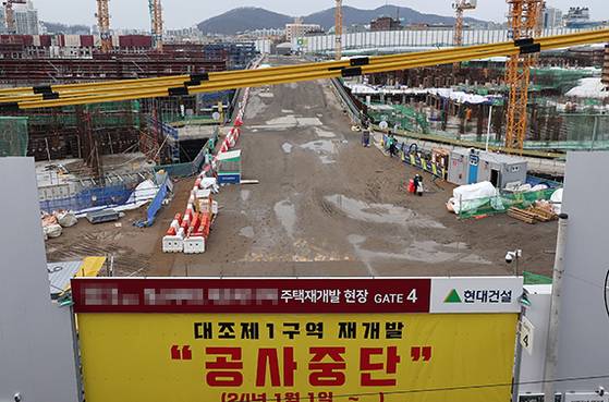 서울 강북권의 한 재개발 사업 지역 공사 현장 입구에 공사비 미지급 관련 분쟁에 따른 공사 중단 안내문이 걸려 있다. [뉴스1]