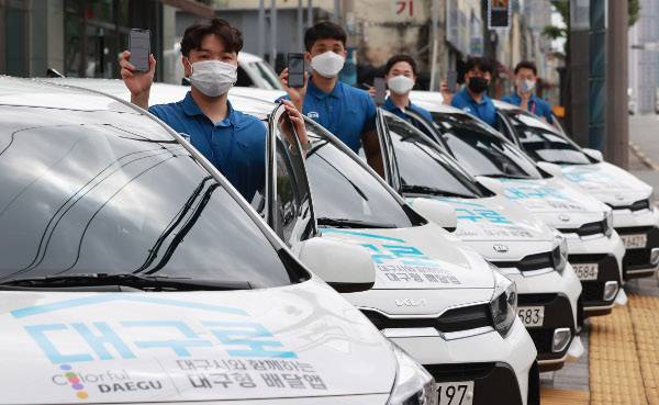 음식 배달 중개 수수료를 낮춘 대구형 배달앱 ‘대구로’ 시범 서비스가 시작된 2021년 8월 10일 대구 서구 비산동 대구로 본사 앞에서 직원들이 영업용 차량 앞에서 앱을 들어 보이고 있다. 뉴시스