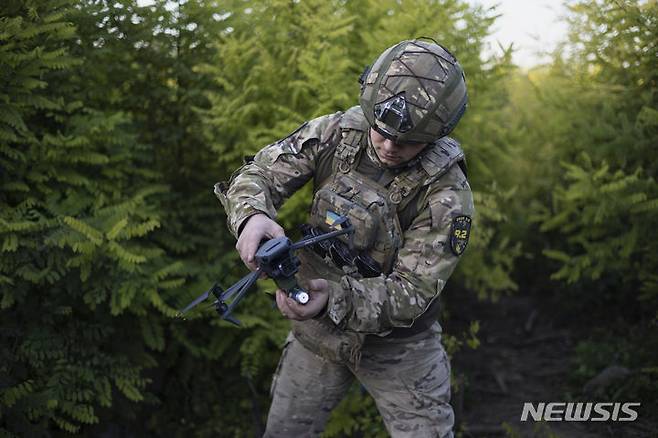 [클리시치우카=AP/뉴시스]지난해 9월24일(현지시각) 우크라이나 도네츠크주 클리시치우카 전선에서 한 우크라이나 군인이 러시아 진영으로 드론을 띄우기 전 수류탄을 부착하고 있다. 2024.03.17.