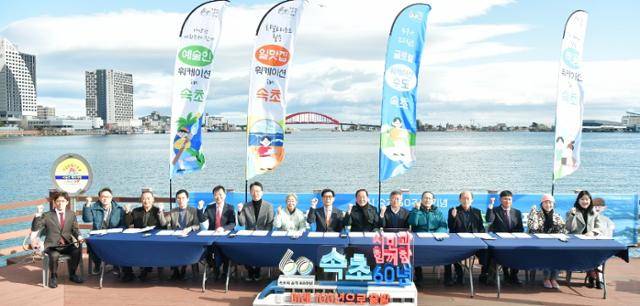 이병선(오른쪽 일곱 번째) 속초시장을 비롯한 지난 11월 강원 속초시 청초정에서 열린 ‘글로벌 워케이션 수도 선포식’에 참석자들이 세계적인 관광지 도약을 다짐하는 파이팅을 외치고 있다. 속초시 제공