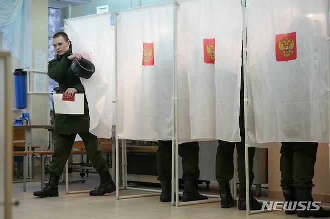 [상트페테르부르크=AP/뉴시스] 15일(현지시각) 러시아 상트페테르부르크의 한 투표소에서 대통령 선거 기표를 마친 러시아 군인이 투표함이 있는 곳으로 나오고 있다. 블라디미르 푸틴 대통령의 재선이 확실시되는 러시아 대선 투표가 15일부터 3일간 이어진다. 2024.03.15.