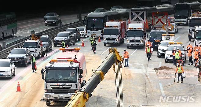 [성남=뉴시스] 김근수 기자 = 19일 경기 성남시 경부고속도로 판교IC 인근 서울 방면 도로에서 한국도로공사 직원들이 도로에 쏟아진 잔해물을 정리하고 있다. 소방과 경찰에 따르면 이날 오전 6시쯤 경기 성남시 인근 경부고속도로 판교IC 양재방면 도로에서 A(60대)씨가 몰던 25톤 트레일러와 B(50대)씨가 운전하던 25톤 덤프트럭이 충돌했다. 2024.03.19. ks@newsis.com