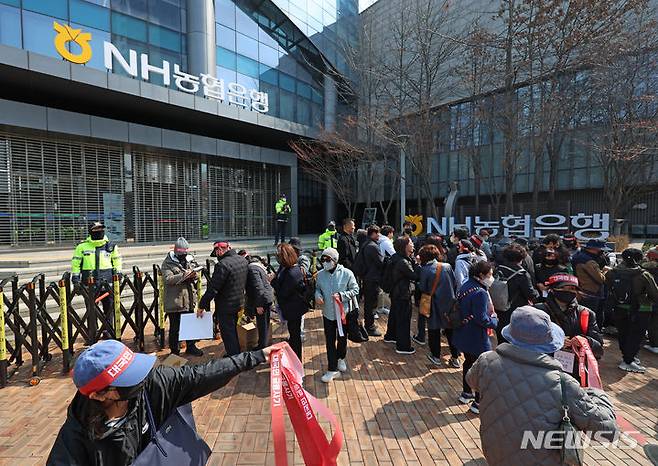 [서울=뉴시스] 김금보 기자 = 홍콩H지수(항셍중국기업지수) 기초 주가연계증권(ELS) 피해자 모임 회원들이 15일 오후 서울 중구 NH농협은행 앞에서 열린 '대국민 금융 사기 규탄 집회'에서 탄원서를 작성하고 있다. 2024.03.15. kgb@newsis.com