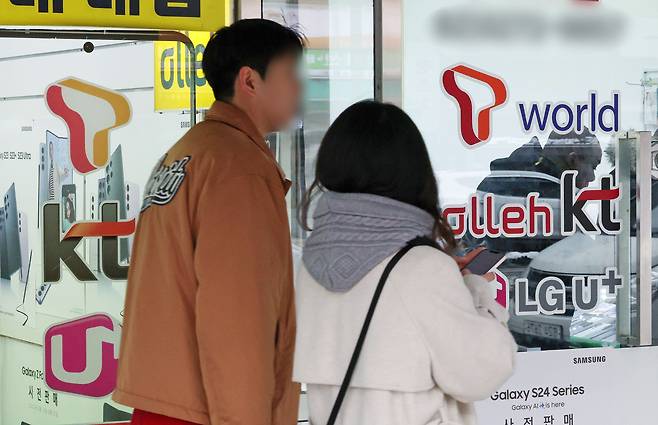 서울의 한 휴대폰 매장 앞을 시민들이 지나가고 있다./뉴스1