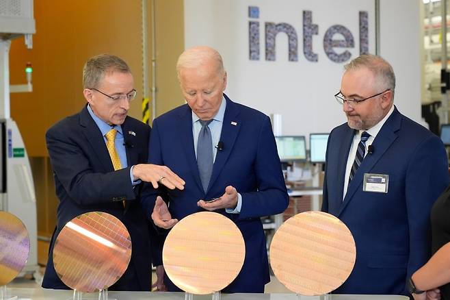 20일(현지시간) 조 바이든(가운데) 미국 대통령이 미 애리조나주에 있는 인텔 캠퍼스에서 팻 겔싱어 인텔 최고경영자(CEO·왼쪽)로부터 제품 설명을 듣고 있다. 사진=AP