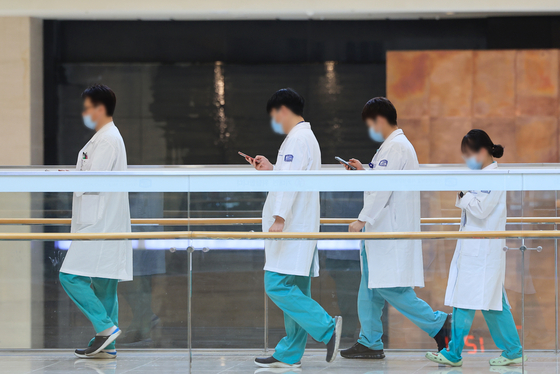 Medical professionals walk inside a general hospital in Seoul on Wednesday. [YONHAP]