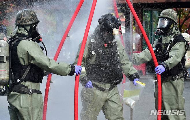 [칠곡=뉴시스] 이무열 기자 = 2022년 10월25일 오후 경북 칠곡군 왜관읍 한 2차전지 소재 생산업체에서 열린 '민·관·군 통합 화학사고 대응훈련'에서 육군 50사단 화생방테러특수임무대 장병들이 테러로 인해 누출된 화학물질을 처리한 후 간이 인체 제독소를 통과하고 있는 모습. 2022.10.25. lmy@newsis.com