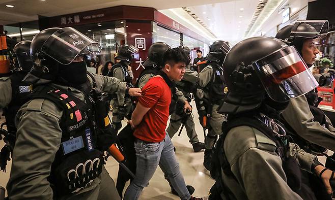 지난 2019년 12월 28일 홍콩 셩슈이 지역의 쇼핑몰에서 반정부 시위를 벌이던 한 남자를 경찰이 연행하고 있다. EPA연합뉴스