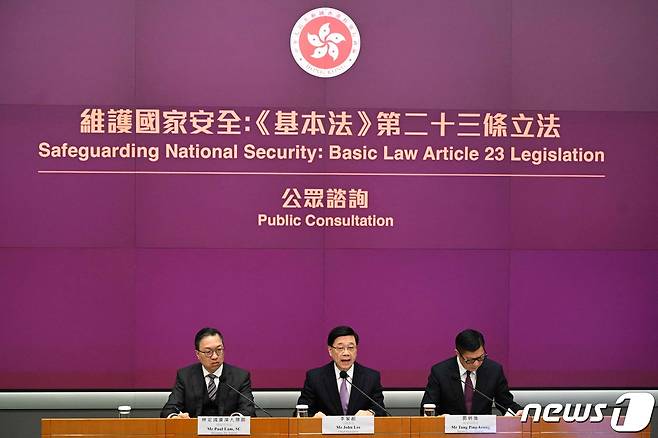 존 리 홍콩 행정장관(가운데)이 30일 홍콩 정부청사에서 폴 램 법무장관(왼쪽)과 크리스 탕 안보장관이 배석한 가운데 홍콩 기본법 제23조의 하위법률에 해당하는 자체 국가보안법 제정을 추진한다고 밝혔다. 이날 관련 협의문을 입법회에 제출한 홍콩 정부는 오는 2월28일까지 의견 수렴 절차를 진행한다. 2024.1.30. ⓒ AFP=뉴스1 ⓒ News1 김성식 기자