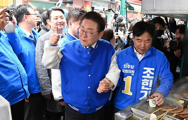 더불어민주당 이재명 대표가 22일 오전 충남 서산시 동부시장을 찾아 음식을 구매하고 있다. [연합]