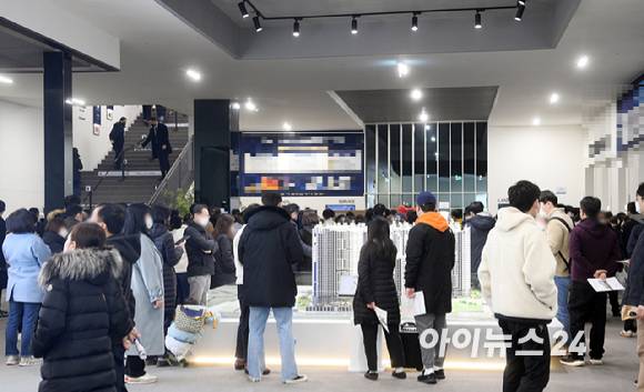 견본주택 방문객들이 단지 모형도를 둘러보고 있다. [사진=정소희 기자]