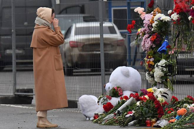 러시아 모스크바에서 테러가 일어난 후 23일(현지시간) 현지 크로커스 시청 앞 임시 기념비에서 한 여성이 애도하고 있다. (사진=AFP)