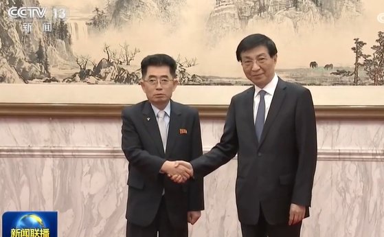 22일 베이징 댜오위타이에서 김성남(왼쪽) 북한 노동당 국제부 부장이 왕후닝(오른쪽) 중국 전국정치협상회의 주석과 회담에 앞서 악수하고 있다. CC-TV 캡처