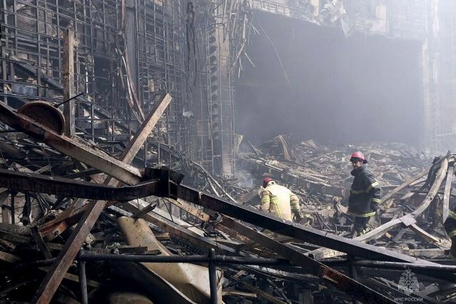 소방관들이 23일(현지시간) 러시아 모스크바 서쪽 대형 콘서트장에서 발생한 화재 현장을 살펴보고 있다. AP연합뉴스