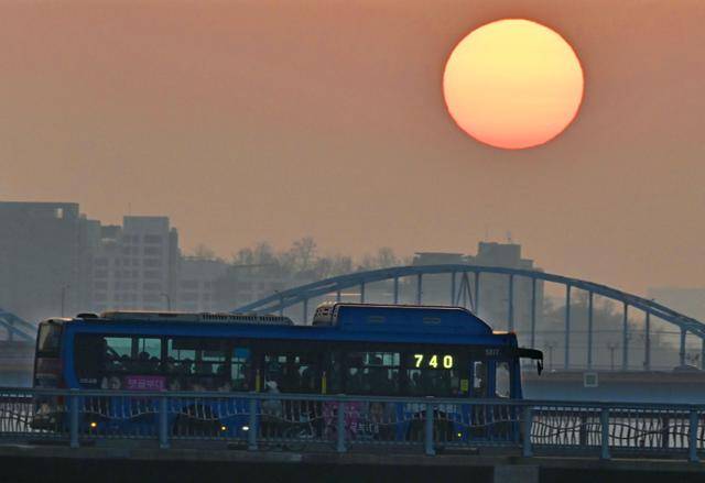 한강에 노을이 붉게 물든 저녁 무렵 동작대교 아래로 태양이 서서히 저물어가고 있다.