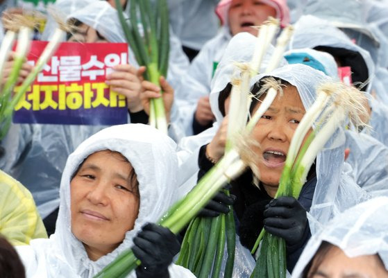 '국민과 함께하는 농민의길' 주최로 25일 오후 정부세종청사 기획재정부 앞에서 열린 수입농산물 철폐 전국농민대표자대회에서 한 참가자가 양손에 대파를 들고 구호를 외치고 있다. 연합뉴스