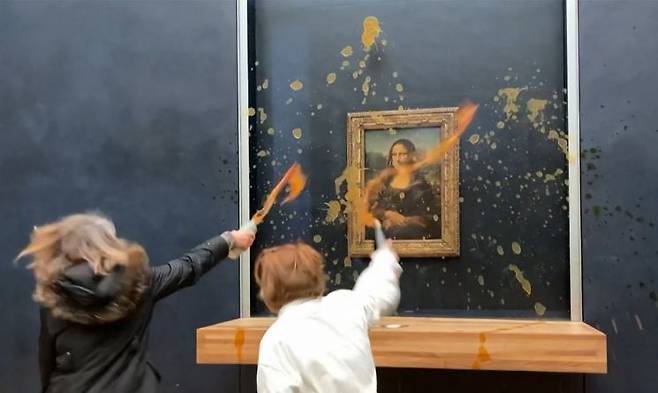 지난 1월 프랑스 파리 루브르박물관에서 환경운동가들이 '모나리자' 그림에 수프를 투척하고 있다. [이미지출처=연합뉴스]