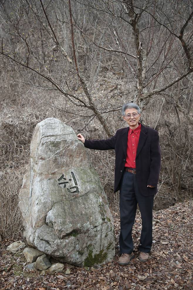 정광일 목사가 가락재 영성원의 영성을 담은 '쉼' '숨' '섬'을 한 글자로 표현한 '쉄'을 새긴 돌 앞에 서있다. / 장련성 기자